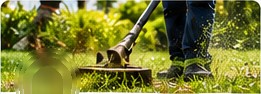 Worker trimming weeds on a lawn